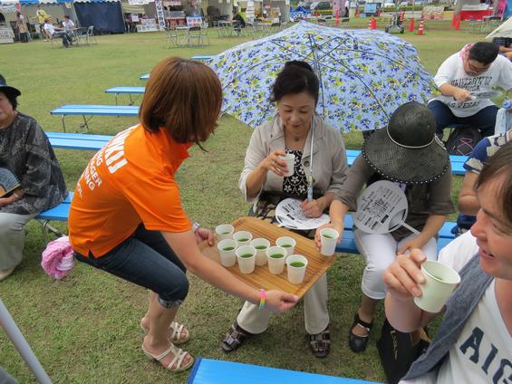 市民にグリーンティーをふるまう、池田リーダー（上部写真）